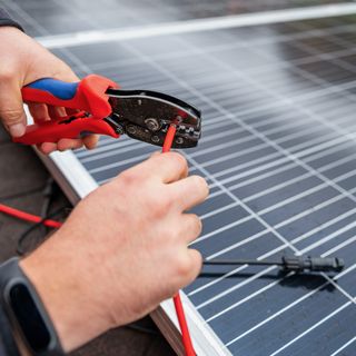 installing solar panel with crimping tool and screw driver