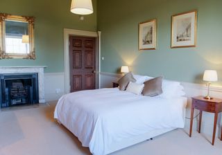 bedroom with green wall and table lamp