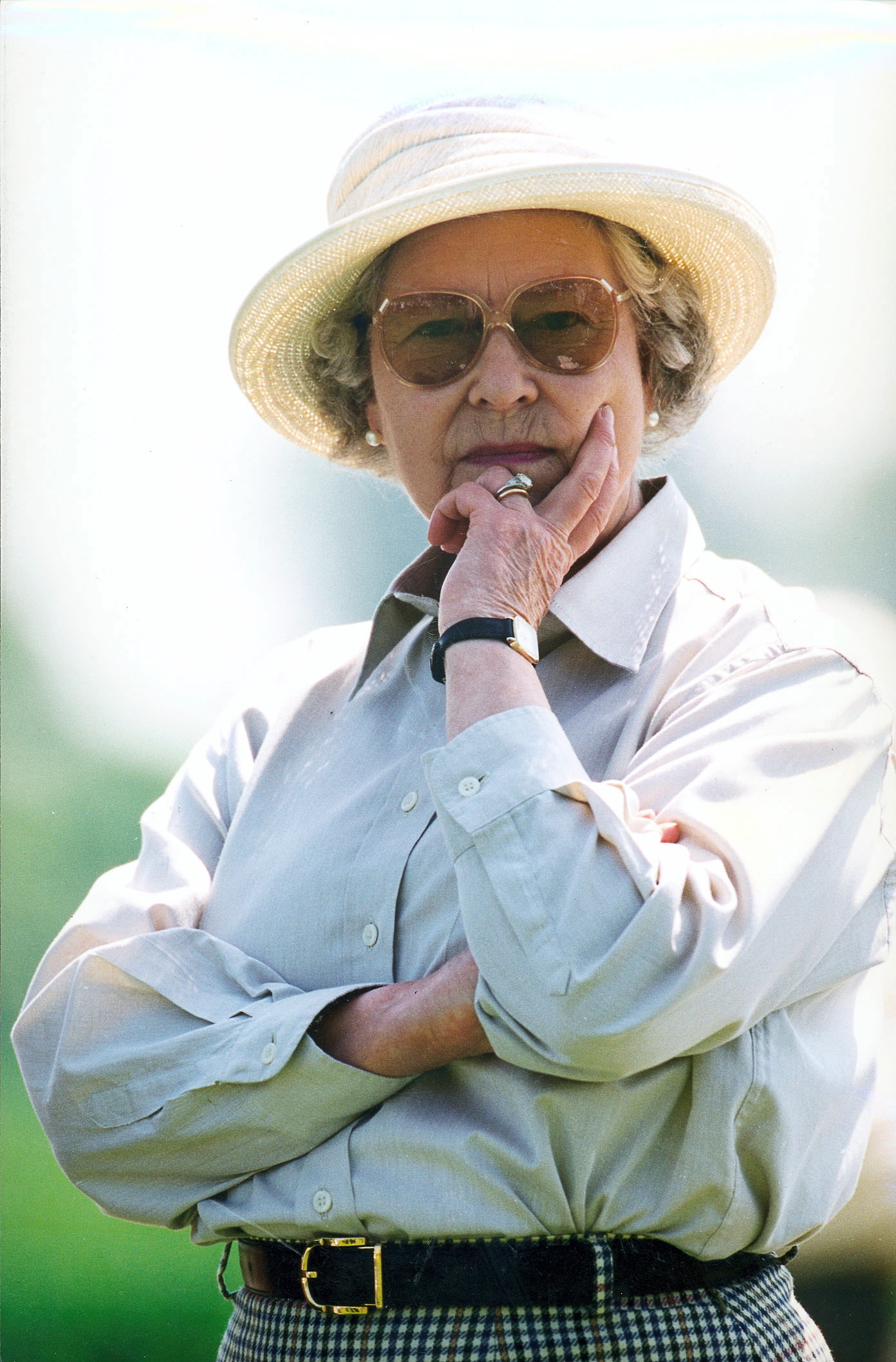 Queen Elizabeth wearing a sun hat and button up shirt