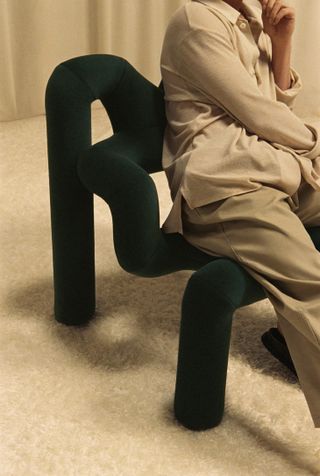 Person sitting on dark green Ekstrem chair by Varier