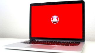 Laptop screen with red background and a warning sign in the middle