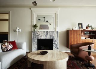 A living room with a built-in fireplace, a curving sofa and two armchairs