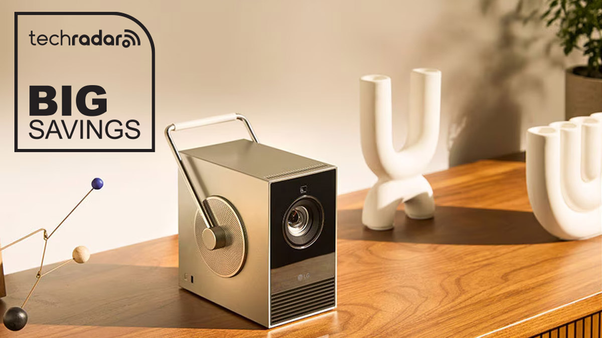 LG CineBeam Q projector on a side table with TechRadar logo and "Big Savings" text in black