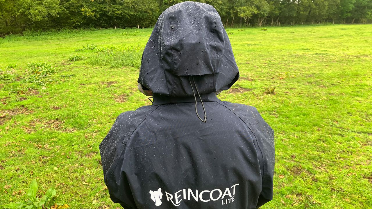 Lady wears Reincoat Lite, viewed from the Back showing a close up of rain on material