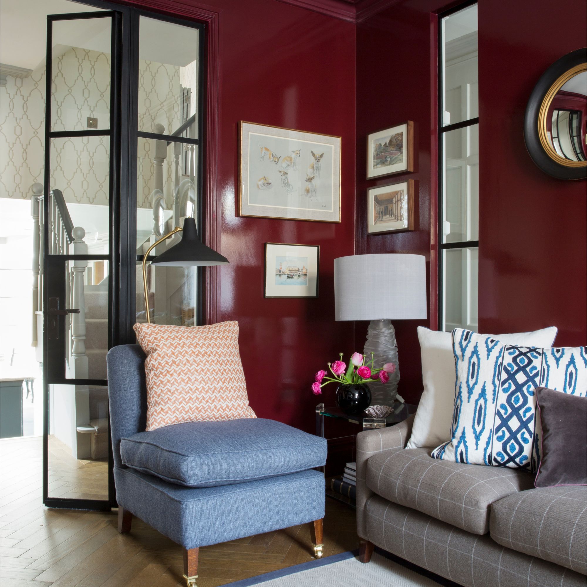 Glossy burgundy living room with blue armchair and gray sofa
