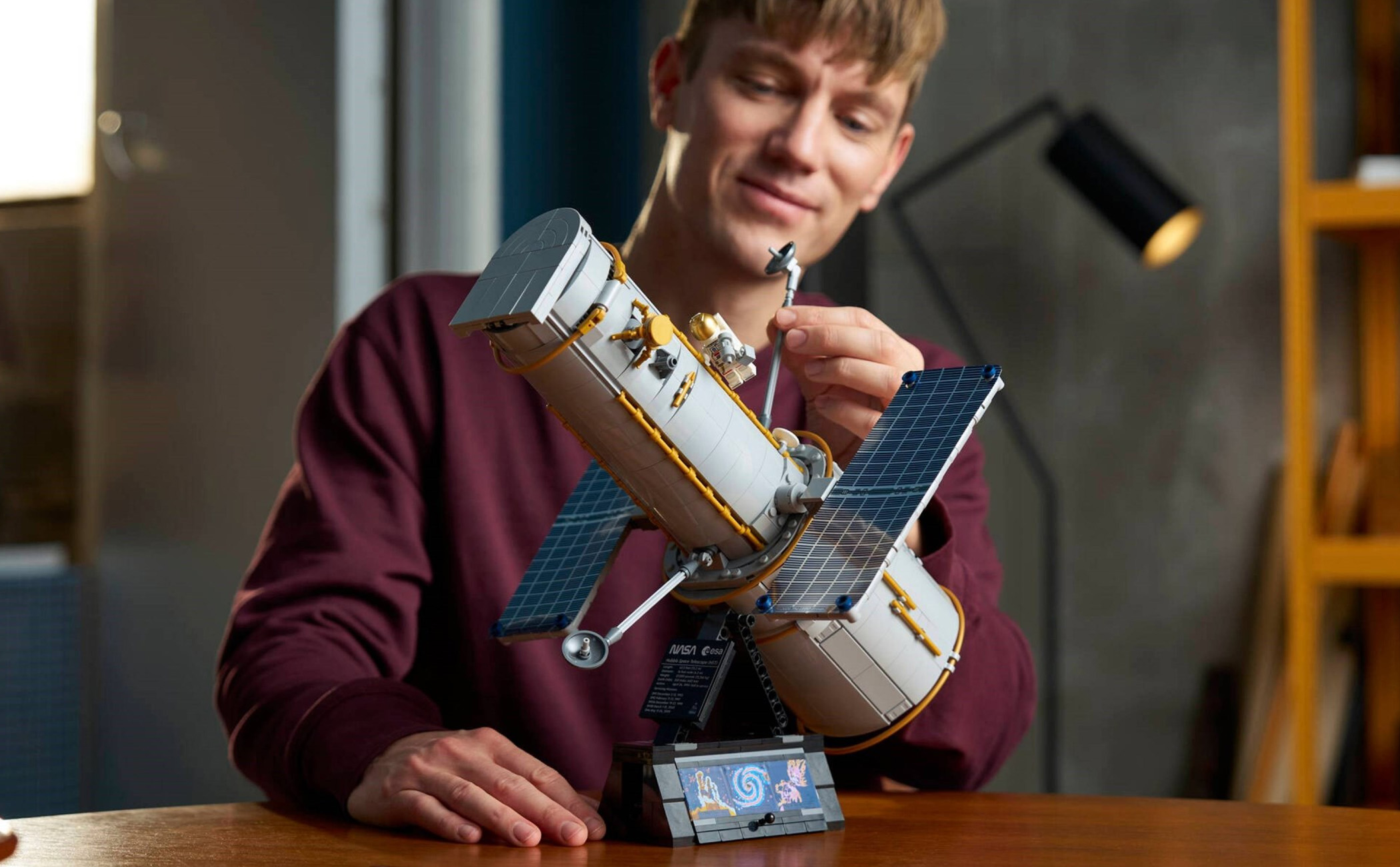 A person manipulating a built Lego Icons Hubble Space Telescope 11382 set