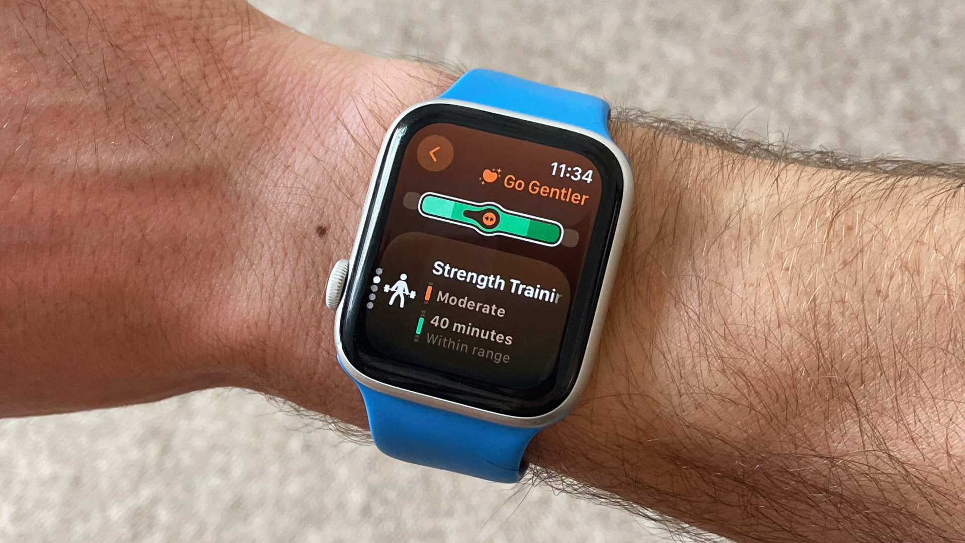 A person wearing an Apple Watch with the Gentler Streak app on the watch face.