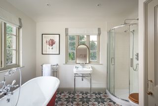 modern bathroom with red bath and heritage tile pattern flooring