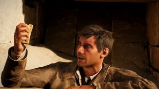 Indiana Jones and the Great Circle trailer screenshot showing Indiana Jones, a man with short brown hair in a worn brown coat examining a stone in his right hand