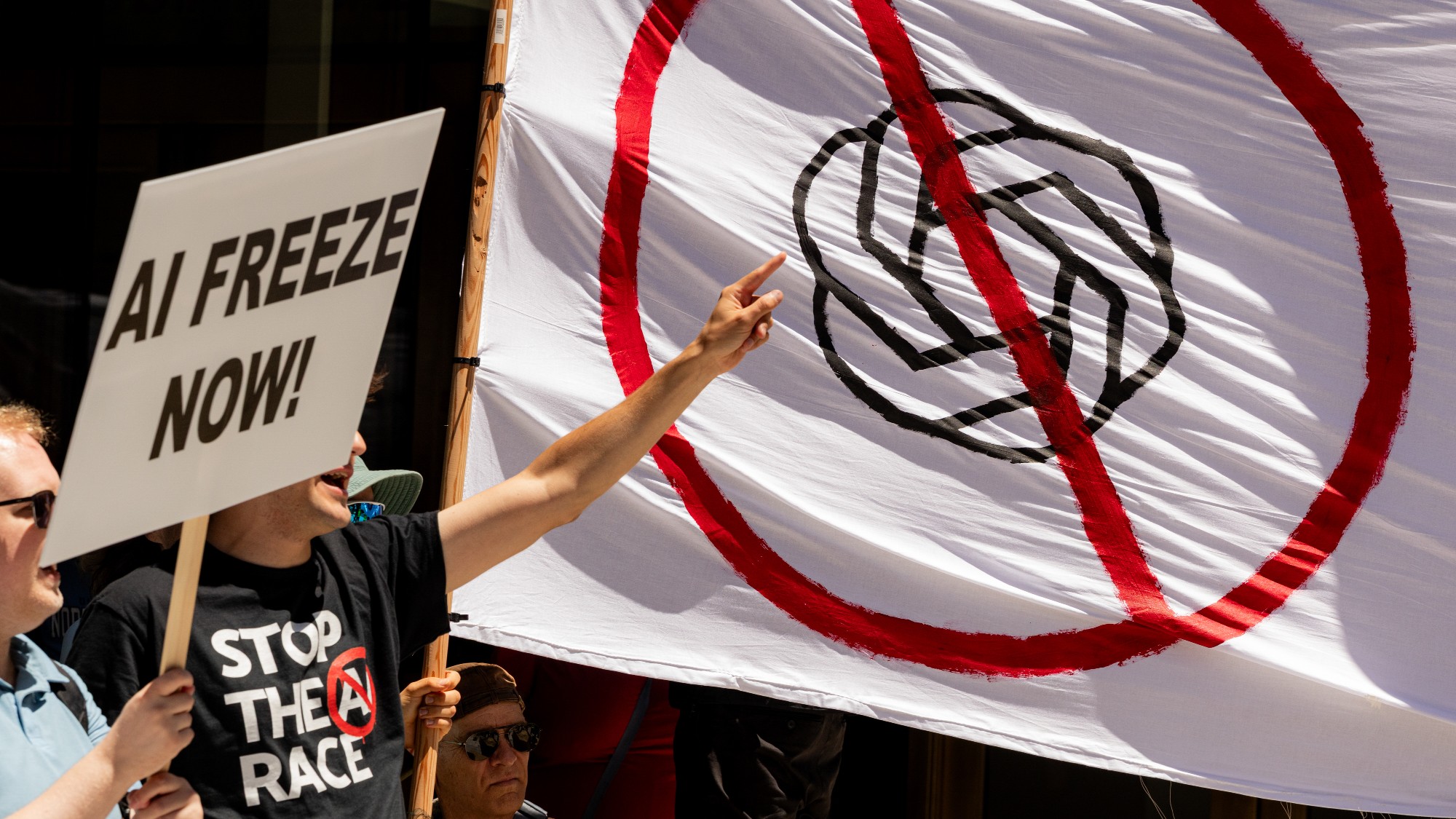 outside Open AI headquarters, demonstrators hold anti-Ai signs 