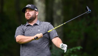 Knost holds his driver with one hand after a poor tee shot