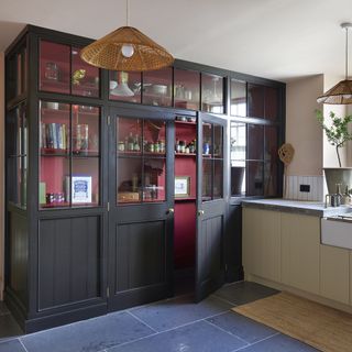 Red pantry with black doors with glass panel in kitchen