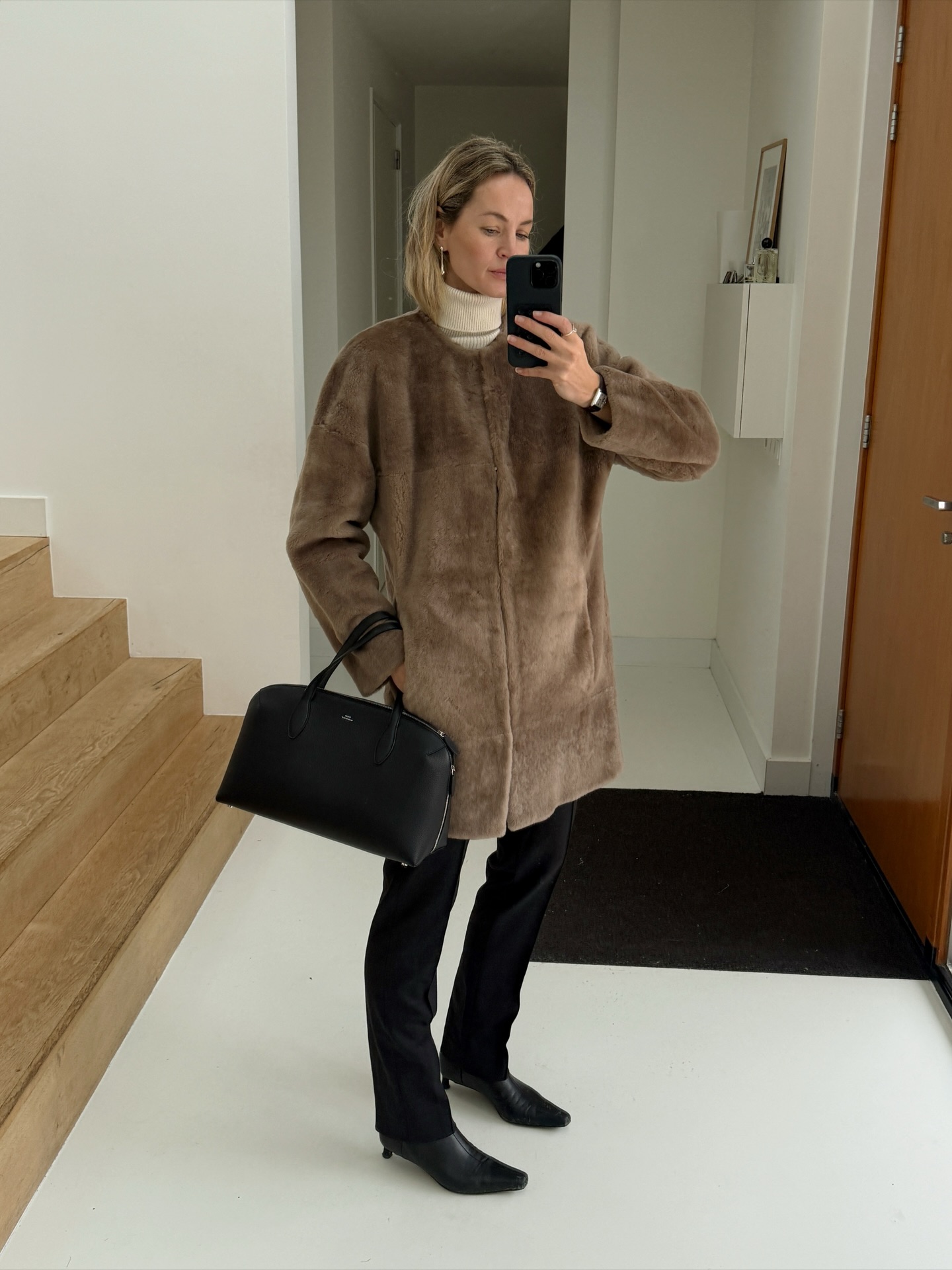 Street style photo of woman wearing a long fur coat.