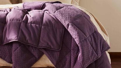 Purple weighted blanket draped on couch