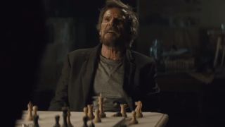 Jesper Christensen shouting while sitting behind a chess set in Spectre.