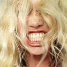 a blonde person showing their teeth