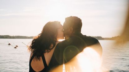 Woman and man kiss outside