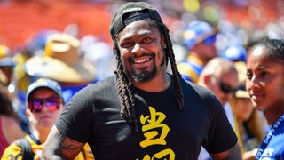 A retired Marshawn Lynch smiling while on the football field