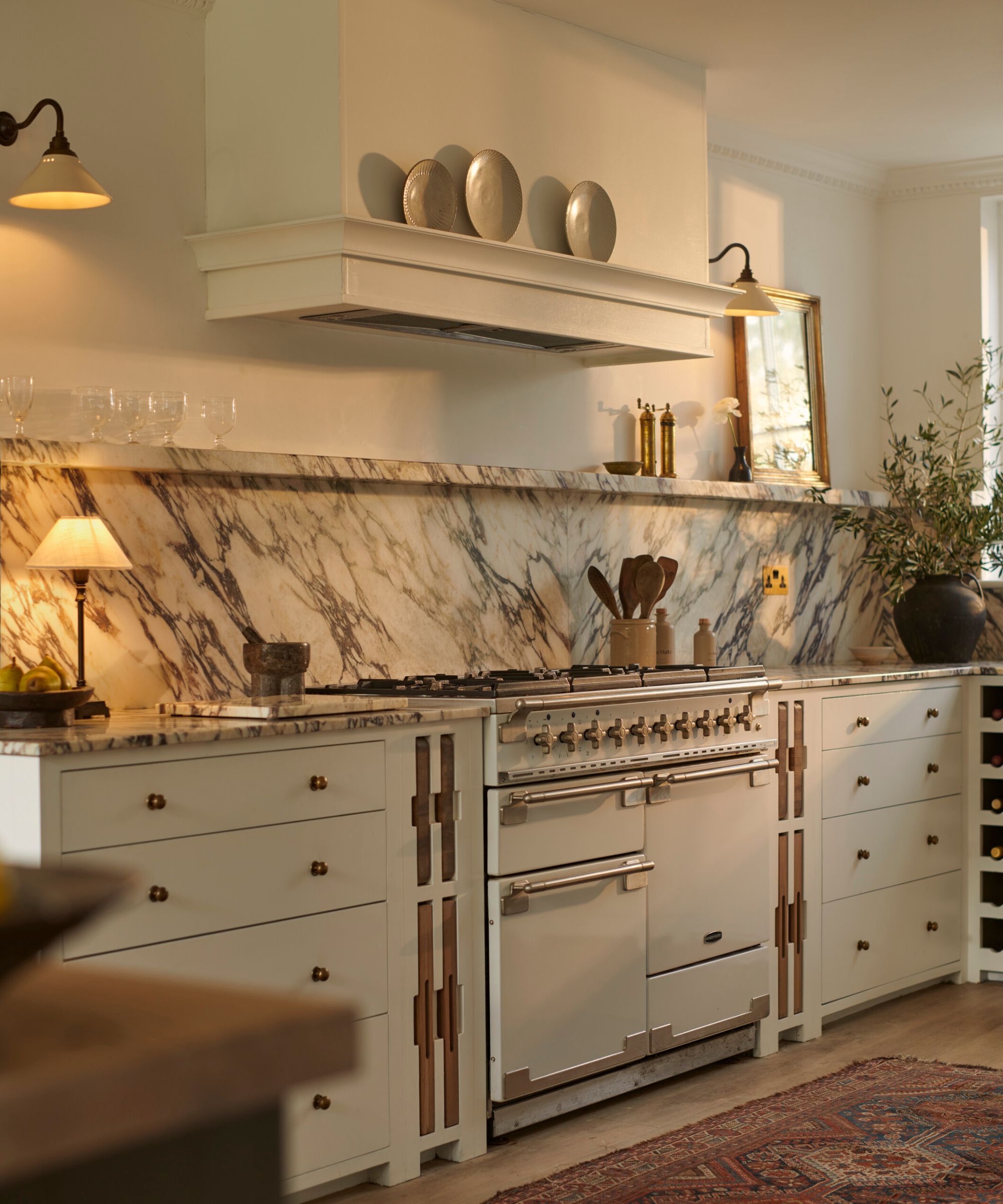 A white kitchen with white cabinets and marble countertops and backsplash