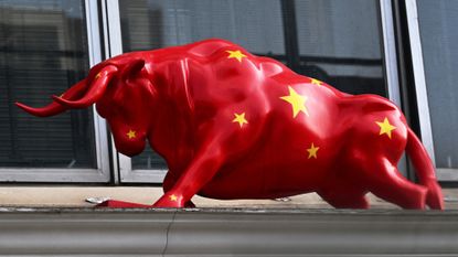 A sculpture of a bull decorated in the Chinese flag is seen above a securities exchange in Hong Kong