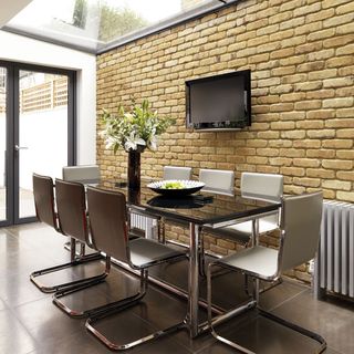 dining area with bricked wall and dining table with chairs