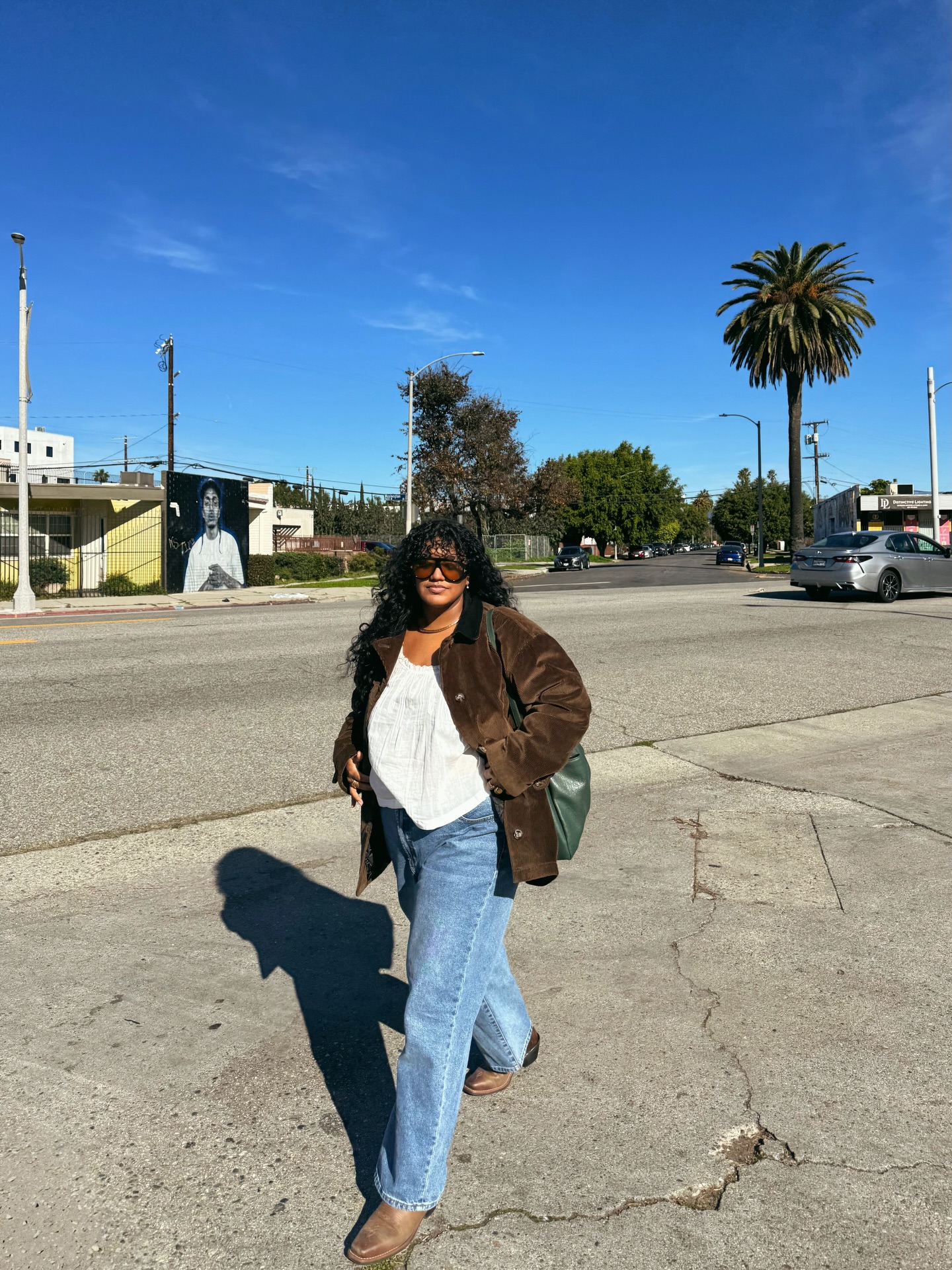 Influencer Veronica Campos wearing a boho top, suede jacket, straight leg jeans and boots.