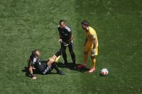 Referee Felix Zwayer is helped with cramp
