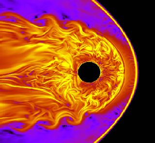 A simulation showing the Earth (as a black circle) surrounded by its magnetic field, the magnetosphere. The solar wind over this layer creates ocean wave-like patterns visible in orange. These are called Kelvin-Helmholtz waves.