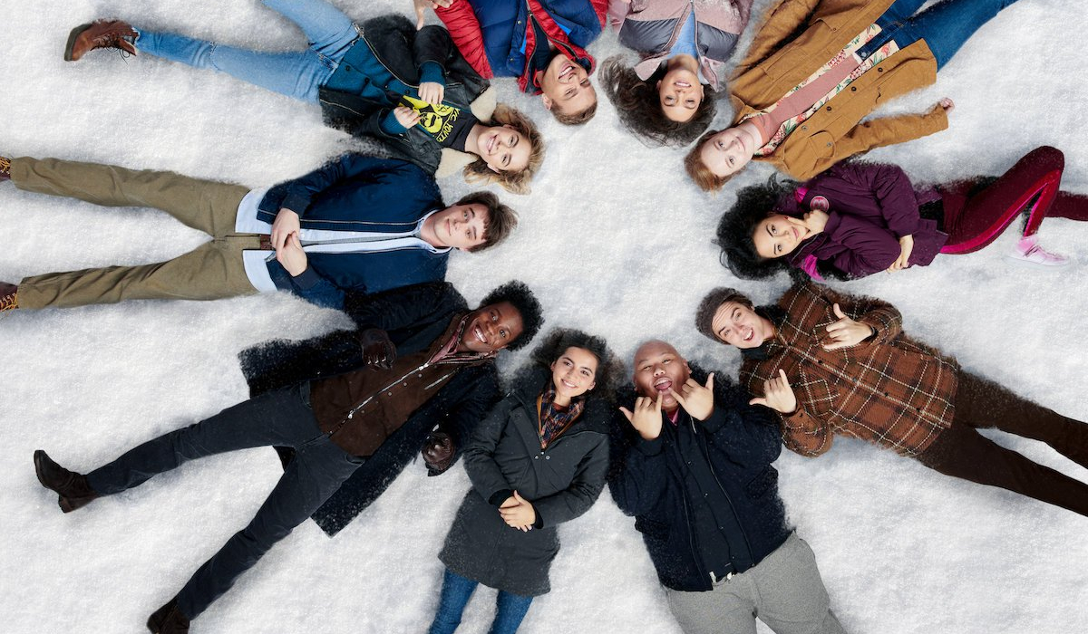 Let It Snow a circle of teens laying in the snow, cheerfully