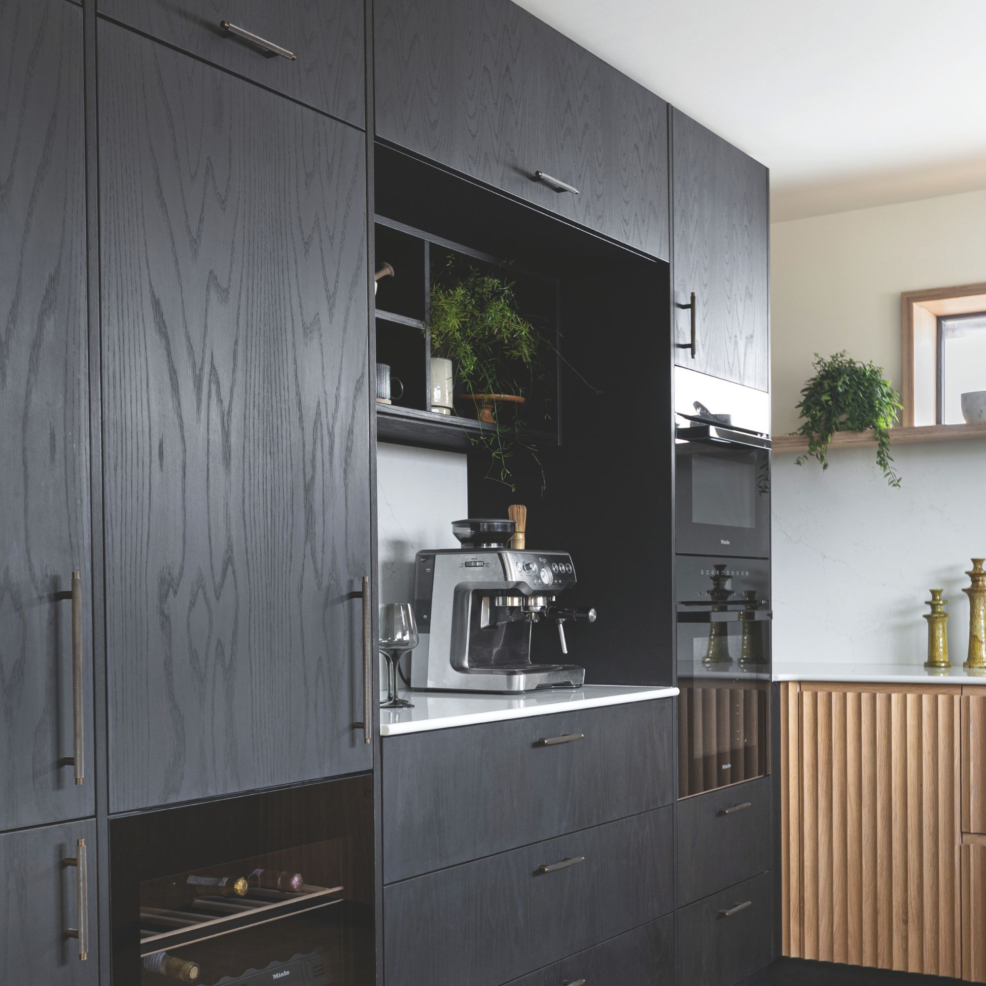 Black kitchen with floor to ceiling units and oak rubbed units on side