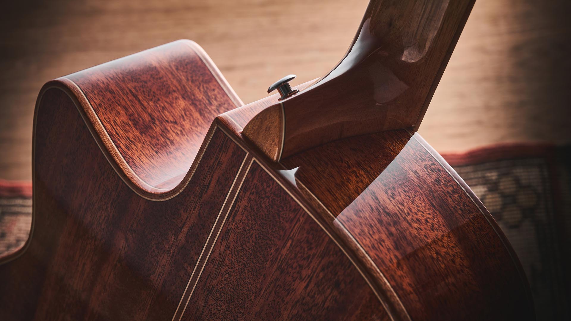 Harley Benton CLG-650SM-CE Black: the handsome but affordable cutaway acoustic isd photographed against a patterned rug on a wooden floor.
