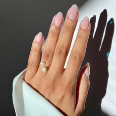 Iram Shelton wearing Essie Allure nail polish on long almond nails