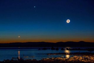 Morning twilight photo of the waning crescent moon shining over the waters of California's Mono Lake, with Jupiter nearby in the upper middle of the photo and Venus at lower left. The photo was captured on Aug. 23, 2014.