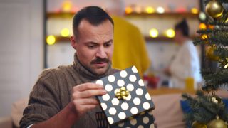 Disappointed man opening Christmas gift