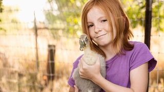 Young girl holding pet duck