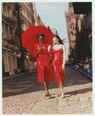 models walking through soho wearing red vinyl coat and vinyl skirt