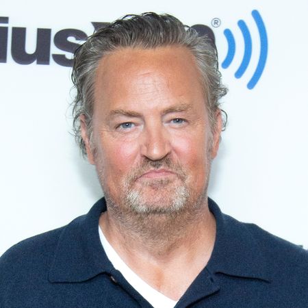 Matthew Perry has gray hair and a beard and wears a navy shirt to visit SiriusXM Studios on November 01, 2022