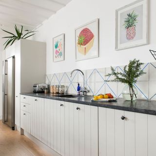 Linear kitchen with light units and dark worktop in side return extension