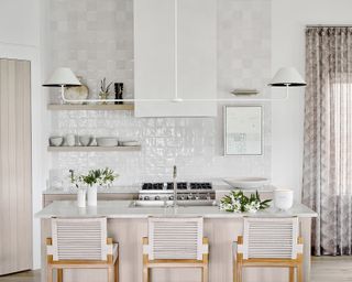 A white kitchen with zellige tiles on the wall