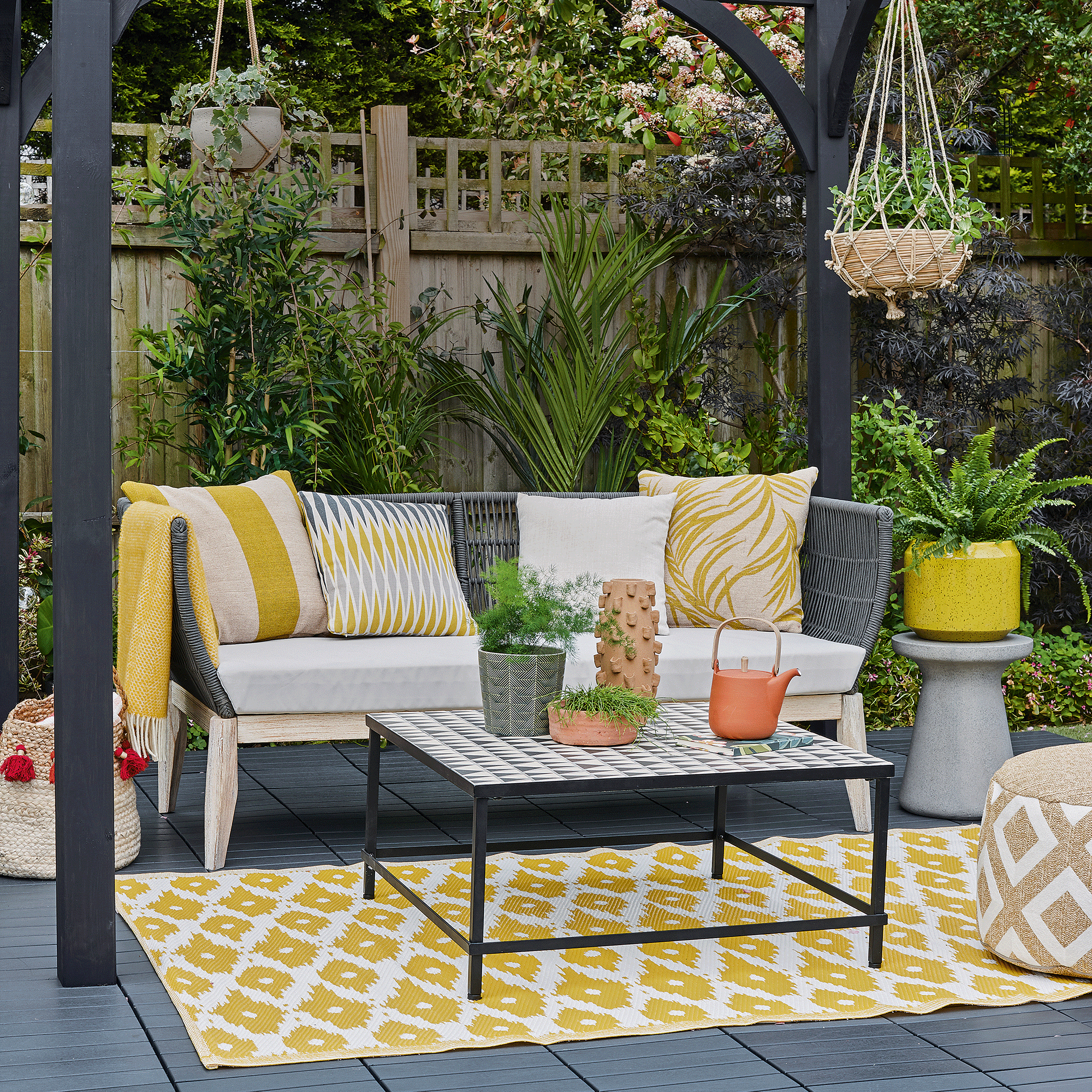 Blue pergola with bench and yellow rug