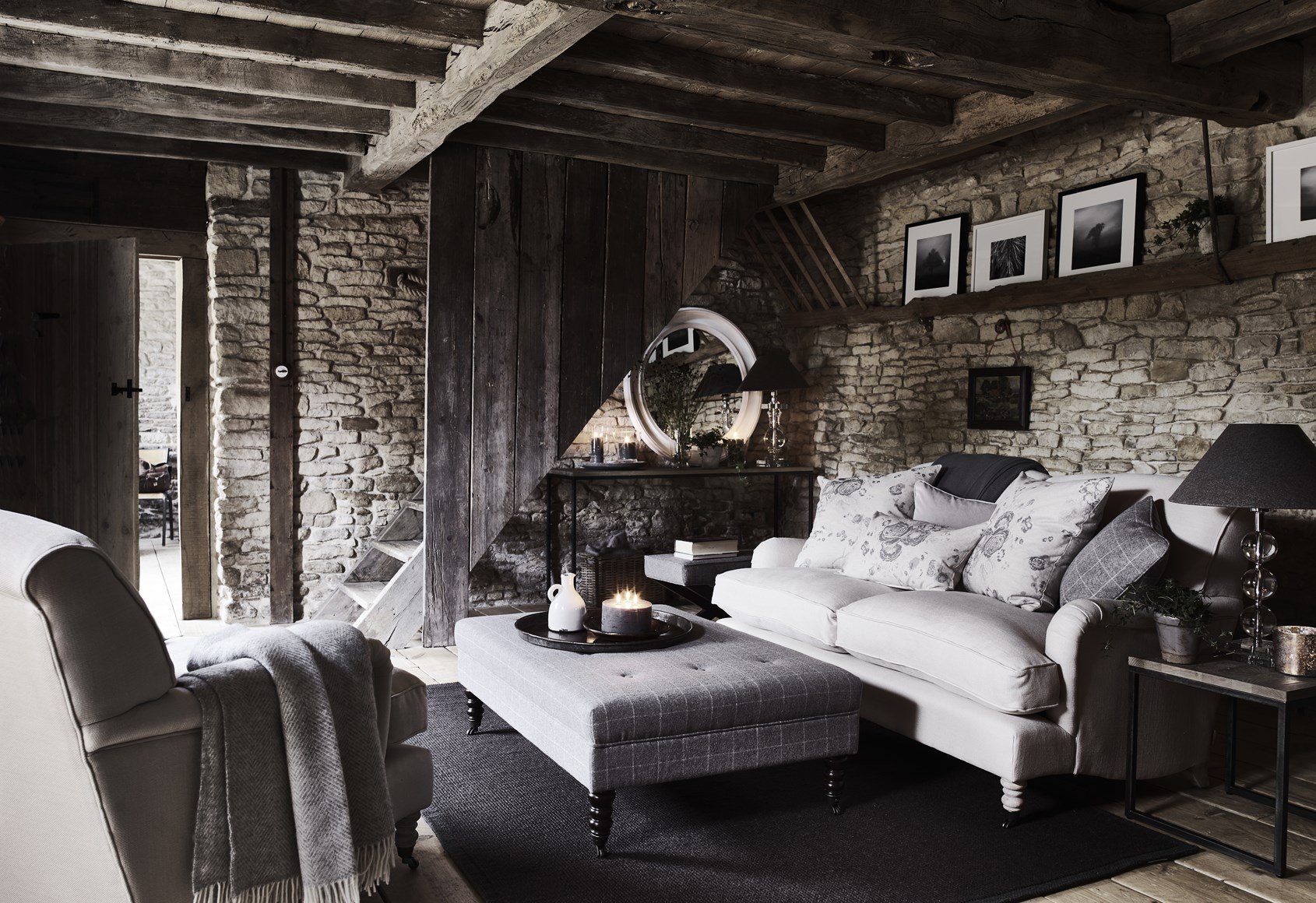 A grey living room by Neptune with exposed brick wall, overhead beams, floating shelves
