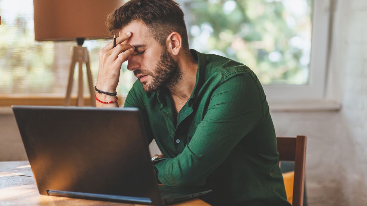 Man looking worried sat in front of laptop