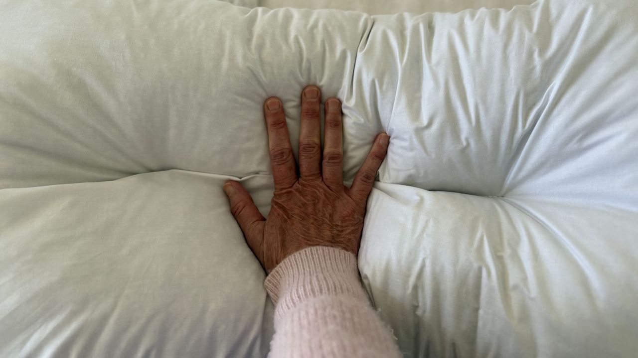 The Naturalmat The Centre Stitched Wool Pillow on a bed