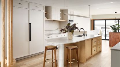 kitchen with white cupboards, light wood island with white marble worktop