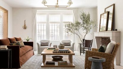 Neutral living room with brown sofa and large stone fireplace