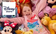 Disney Store logo placed over an image of a girl smiling amongst teddies and plushies of iconic characters