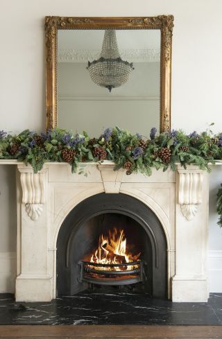 A fireplace decorated with a Christmas garland