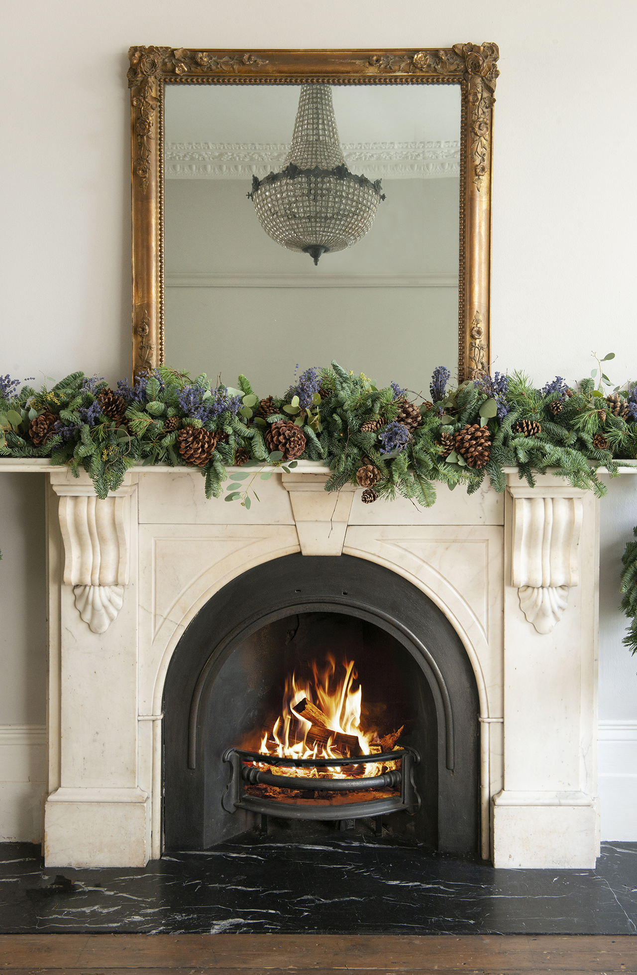 A fireplace decorated with a Christmas garland