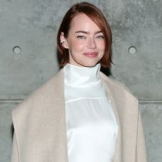 Emma Stone attended a Louis Vuitton bag in a white matching set, a beige coat, and a monogram Louis vuitton bag