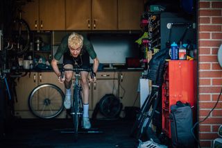 Male cyclist completing a VO2 max workout inside his garage